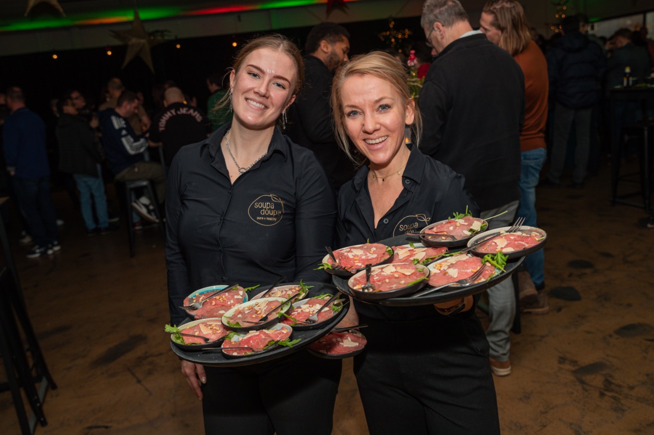 Medewerkers van Soupa Doupa serveren gerechten op een zakelijk kerstfeest